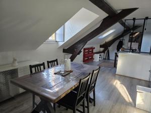 a dining room with a wooden table and chairs at Le Refuge des Bords de Loire in Blois +2 photos