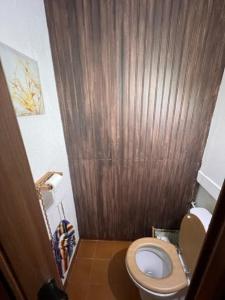a bathroom with a toilet and a wooden wall at Maison de village Provençale in Ubraye