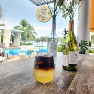 Dos botellas de vino en una mesa de madera con una bebida. en Premium 3bedroom120sqm 15floor วิวทะเล frontbeach seaview, en Jomtien Beach
