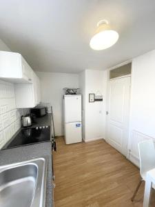ロンドンにあるPerfect Stay Close to Centre Londonのシンクと白い冷蔵庫のあるキッチン