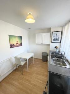 ロンドンにあるPerfect Stay Close to Centre Londonのキッチン(白いテーブル、シンク付) +3枚の写真