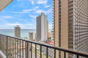 a balcony with a view of the ocean and buildings at Steps to the Beach! Gorgeous Ocean-View Condo with Complimentary Parking (12508) in Honolulu