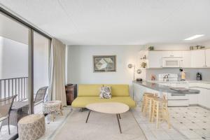 a living room with a yellow couch and a kitchen at Steps to the Beach! Gorgeous Ocean-View Condo with Complimentary Parking (12508) in Honolulu