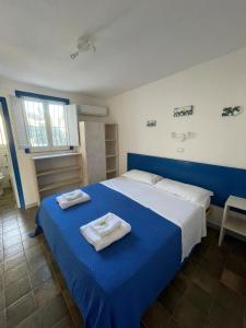 a bedroom with a blue bed with towels on it at Villaggio Turistico Europeo in Catania +56 photos