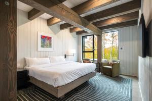 a bedroom with a large bed and a window at NEW! Lagom Tyst Chalet 7 Bedroom Hot Tub Near Resort in Mont-Tremblant