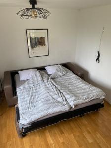 a bed in a bedroom with a picture on the wall at Charming Cottage in Räng Sand in Höllviken