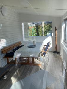 a dining room with a table and a window at Charming Cottage in Räng Sand in Höllviken +8 photos