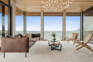 a living room with a couch and a chandelier at Nordic House Lofoten in Ramberg