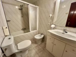 a white bathroom with a toilet and a sink at Apartamento El Corrillo - 5835 in Isla +13 photos