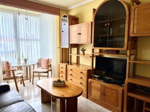 a living room with a couch and a tv and a table at Apartamento El Corrillo - 5835 in Isla