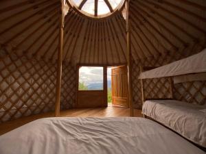 a room with a bed in a yurt with a window at Yourte au coeur des Alpes in Eygliers