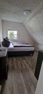 a bedroom with a bed in a room with a window at Quiet place with sauna in Schwarzenbach am Wald