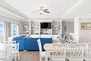 ein Wohnzimmer mit einem blauen Sofa und weißen Stühlen in der Unterkunft Hypnotic your seaside retreat in Holden Beach