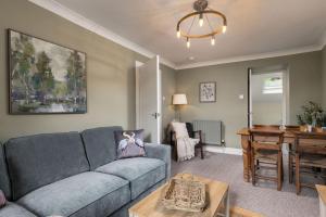 a living room with a blue couch and a table at Central Cathedral Apartment in Dunblane