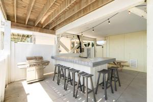 eine Küche mit einer Theke und Hockern in einem Zimmer in der Unterkunft Hypnotic your seaside retreat in Holden Beach
