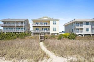 eine Reihe von Häusern am Strand mit einer Feldstraße in der Unterkunft Hypnotic your seaside retreat in Holden Beach