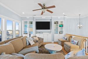 a living room with a couch and a flat screen tv at FREE CABANA - Dock Holiday by Pier 42 in Holden Beach