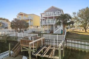 a house with a dock in front of a house at FREE CABANA - Dock Holiday by Pier 42 in Holden Beach