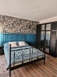a bedroom with a blue bed and a wall at Domki u Magdy in Ustka