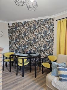 a dining room with tables and chairs and a wallpaper at Domki u Magdy in Ustka +12 photos