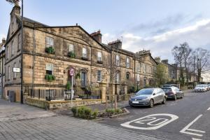 an old building on a street with cars parked in front at The Stirling Garden Townhouse - Private Courtyard in Stirling
