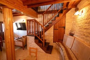 a living room with a wooden staircase in a house at Archontikon 1817 in Kaliana