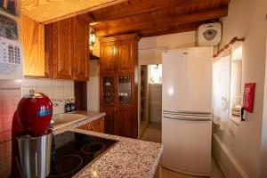 a kitchen with a white refrigerator and wooden cabinets at Archontikon 1817 in Kaliana