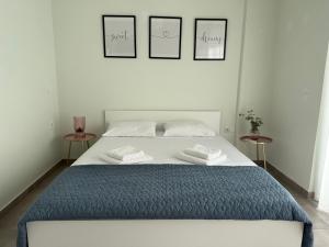 a bedroom with a bed with three pictures on the wall at Karamela Apartment in Kambánion