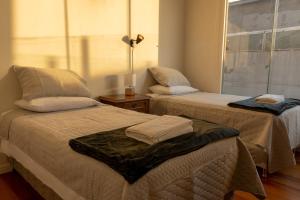 two beds in a room with a window at Tower Center Apartment in La Paz
