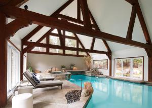 a large swimming pool in a house with a large ceiling at Le Manoir 9 bedrooms Indoor Pool Walk to Resort in Mont-Tremblant