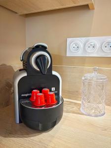 a blender sitting on a counter with red cups at Joli Perot in La Rochelle