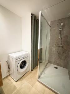 a bathroom with a washing machine and a shower at Joli Perot in La Rochelle