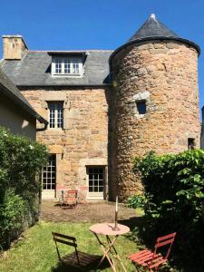 a stone building with a table and chairs in the yard at Résidence D02-tregastel - Vacances près de la mer dans une maison médiévale MAE-4284 in Trégastel