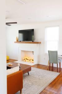 een woonkamer met een open haard en een tv erboven bij Cozy Historic District Cottage in Dothan