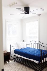 een slaapkamer met een bed met een plafondventilator bij Cozy Historic District Cottage in Dothan