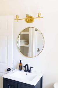 een badkamer met een wastafel en een spiegel bij Cozy Historic District Cottage in Dothan