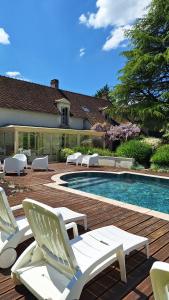 a group of lawn chairs and a swimming pool at Traînefeuilles - Chambres d'hôtes proche Zoo de Beauval in Thenay