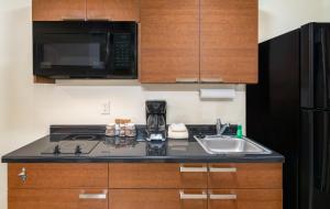 a kitchen with a sink and a microwave at My Place Hotel-Hurricane, UT in Hurricane