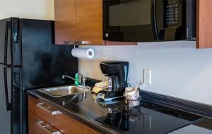 a kitchen with a sink and a coffee maker on a counter at My Place Hotel-Hurricane, UT in Hurricane