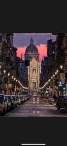 a city street with a building in the distance with cars parked at Testa House 2 0 in Catania