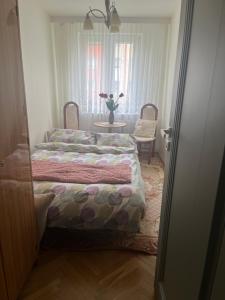 una camera da letto con due letti e un tavolo con un vaso di fiori di Mieszkanko a Koszalin