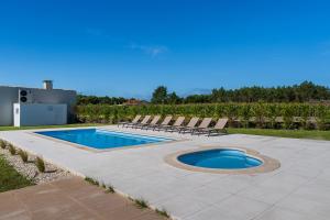 een terras met stoelen en een zwembad bij Villa Ria by Aqualeisure in Ovar