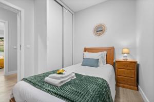 ein Schlafzimmer mit einem Bett mit einer grünen Decke in der Unterkunft River Side in Senhora do Rosário