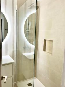 a bathroom with a shower with a sink and a mirror at Vistas de La Barquera in San Vicente de la Barquera +5 photos