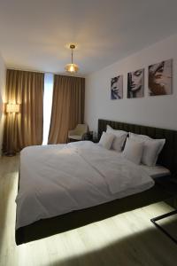 a bedroom with a large white bed and a window at Velvet Central Residence in Văleni +26 photos