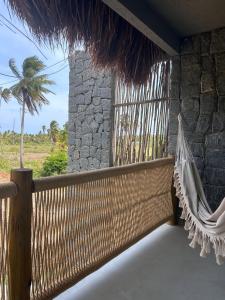un portico con un'amaca e un muro di pietra di Casa Arcanjo - Patacho a Pôrto de Pedras