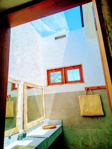 un bagno con lavandino e finestra di Casa Arcanjo - Patacho a Pôrto de Pedras