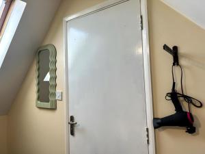 a door in a room with a hair dryer on the wall at Sherry's 2 Bed Guest House in Buckinghamshire