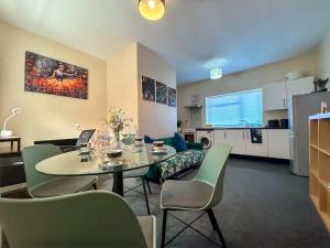 a living room with a table and chairs and a tv at Sherry's 2 Bed Guest House in Buckinghamshire +31 photos