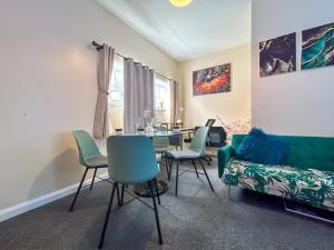 a living room with a table and chairs and a couch at Sherry's 2 Bed Guest House in Buckinghamshire